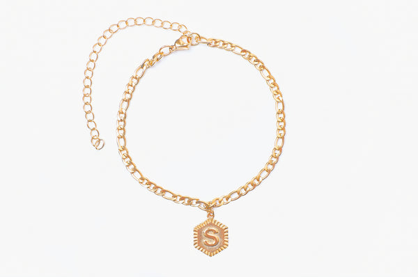Initial anklet. Engrave your initial in uppercase font on a hexagon shape charm. Crafted onto our figaro chain anklet. Chain Length: 21cm + 10cm extender chain. Pendant size 1.4cm. Made with stainless steel, plated with 18K Gold. Chunky jewelry aesthetic.