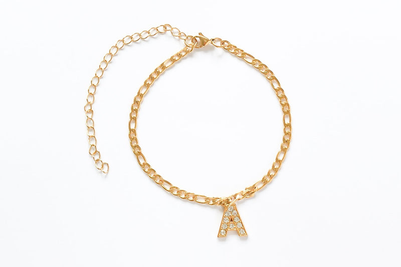 Ice out your initial in capital letter font on our charm anklet. Crafted onto our Figaro chain. Chain Length: 21cm + 10cm Extender Chain. Made with stainless steel, plated with 18K Gold. Chunky jewelry aesthetic. 